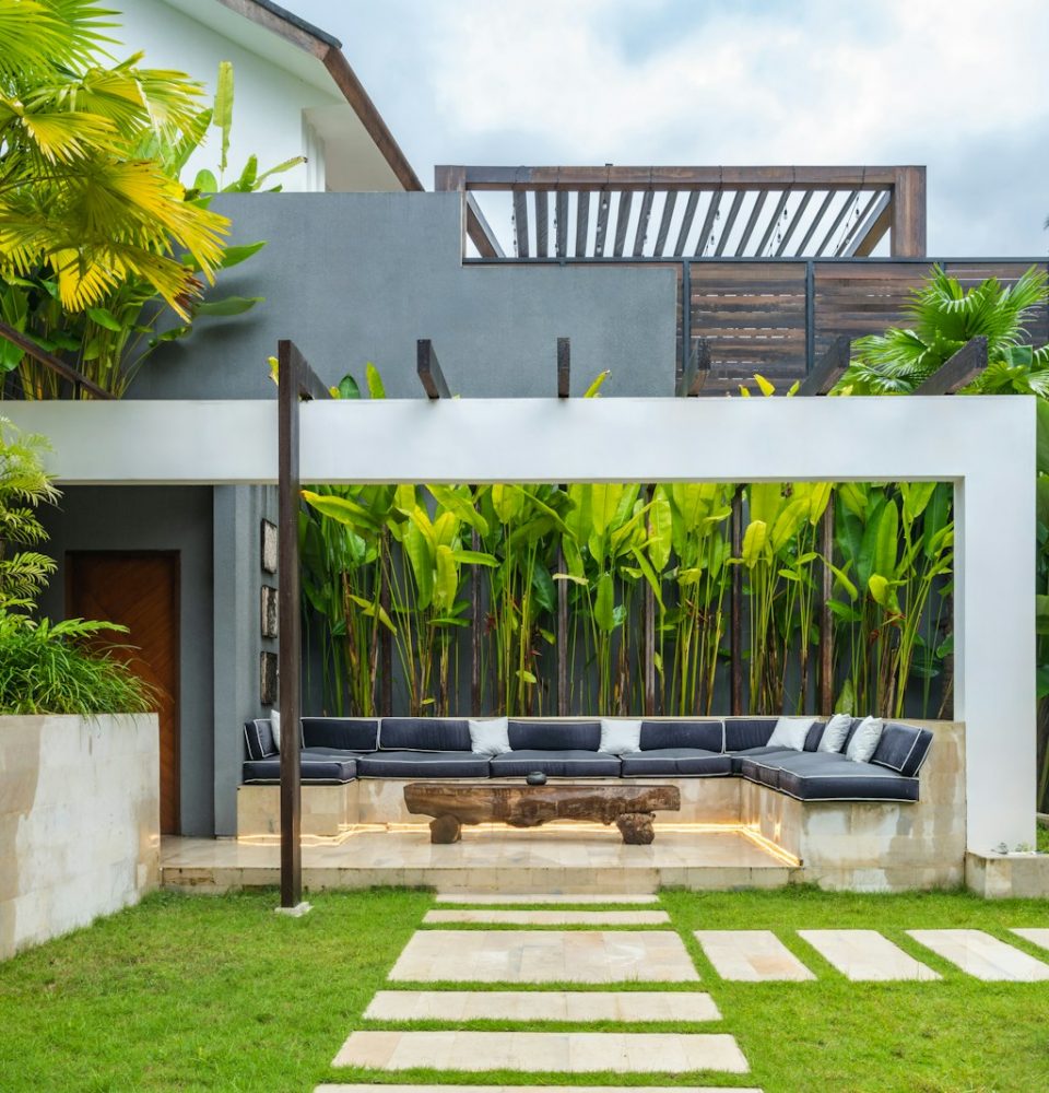 A backyard with a stone path leading to a covered patio